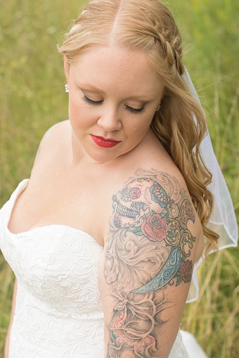 A close up outdoor wedding photography portrait of a tattooed bride