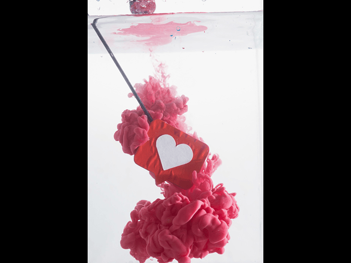 A submerged paper hear icon submerged with acrylic to shoot colorful paint in water photography