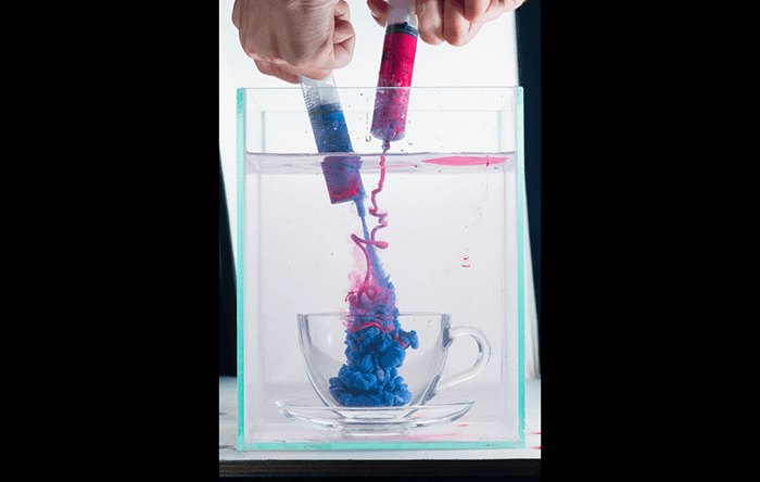 Overhead shot of mixing blue and pink paint to shoot colorful paint in water photography
