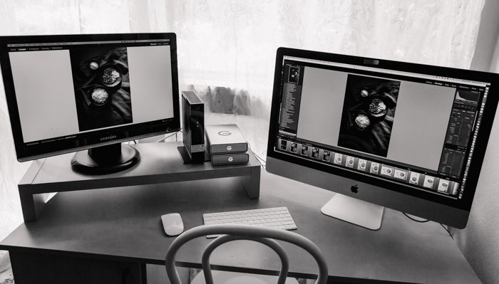 a photographers home office with two laptop screens open on an editing program showing how to print photos professionally 
