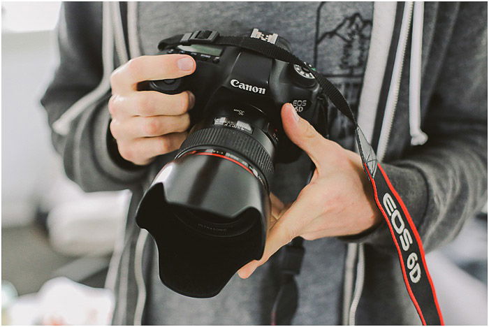 a professional portrait photographer holding a canon DSLR - portrait photography pricing