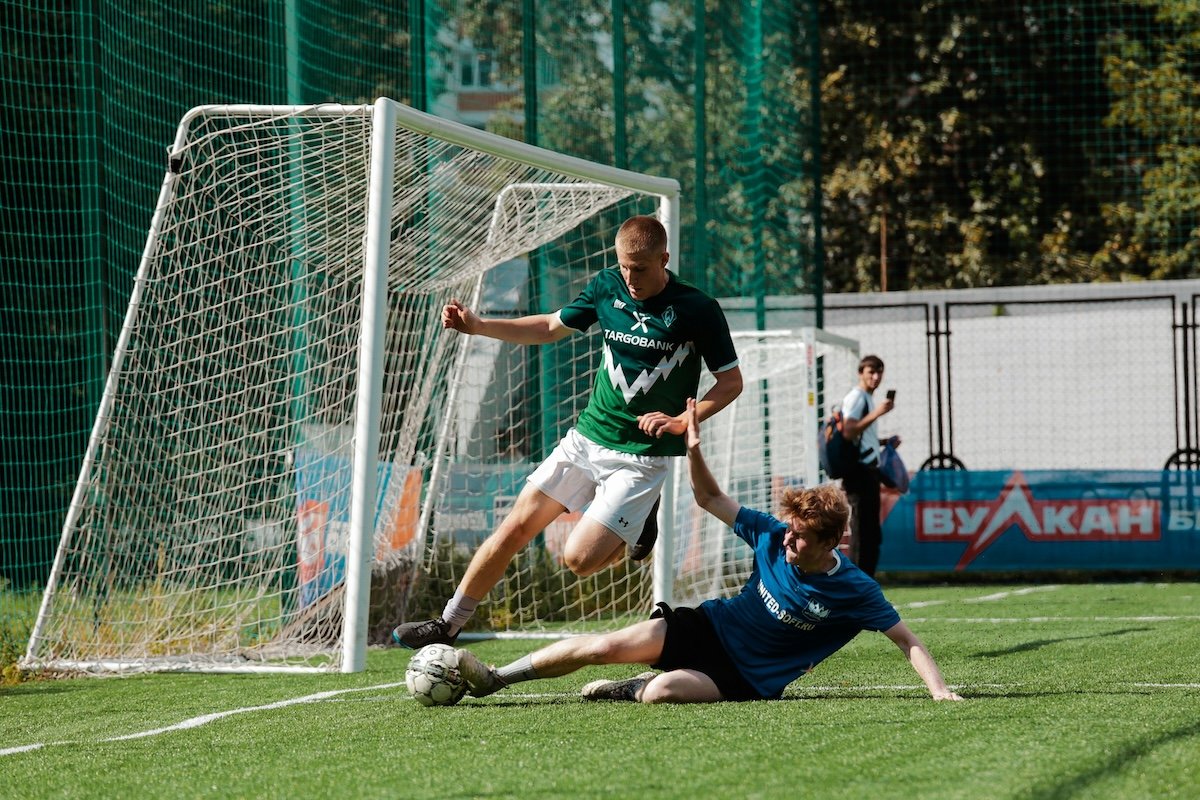 A player making a sliding tackle by a net as an example of soccer photography
