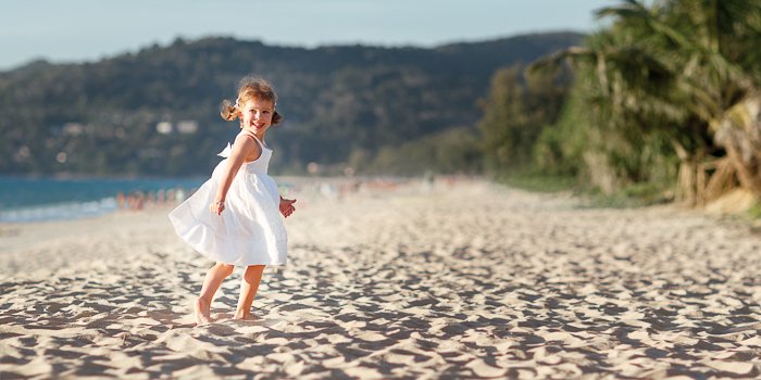 a little girl running on the beach, her action frozen in motion