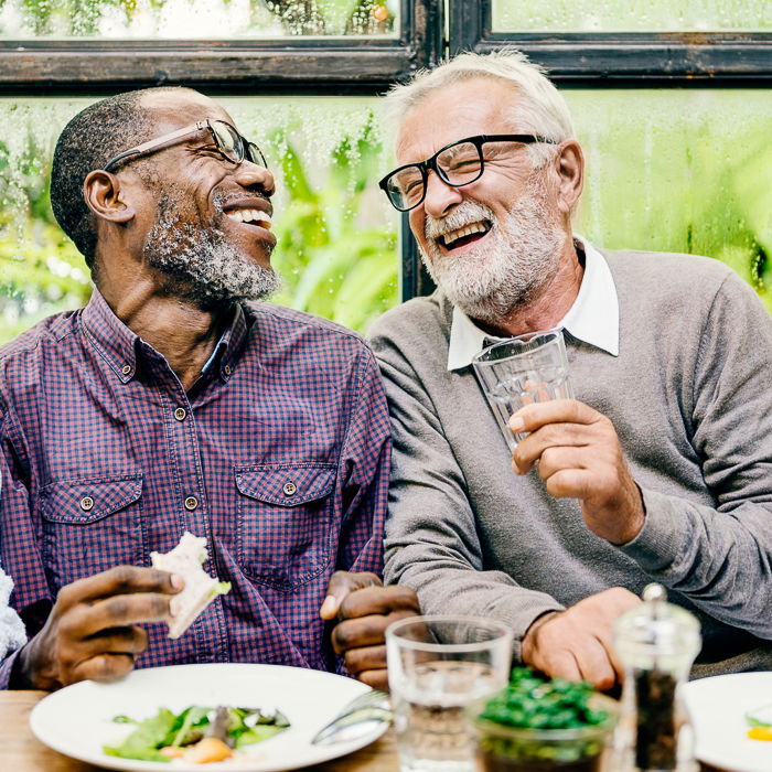 portrait of two male friends laughing over dinner