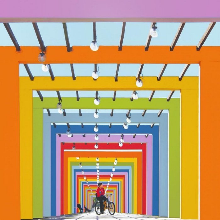 Ciclista em uma estrada com andaimes coloridos como exemplo de fotografia geométrica