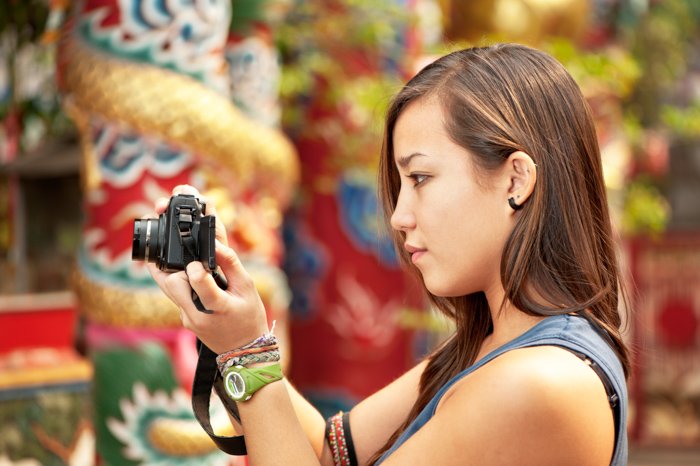 Photo of a woman checking the settings of her camera