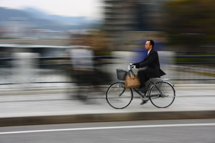 a cyclist moving over a bridge with blurred background