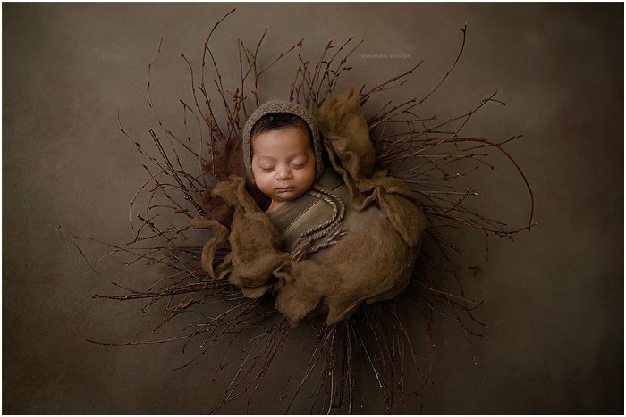 Artistic photo of a baby in front of a brown background