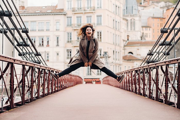 Girl jumps on a symmetrical bridge.