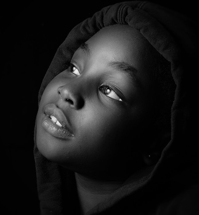 Black and white close-up portrait of a child in soft light
