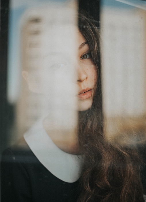 Portrait photo of a woman shot through a window