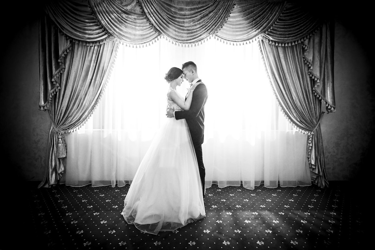A wedding couple facing each other against a symmetrical background as an example of framing in photography
