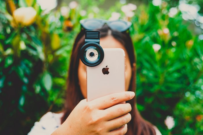 Photo of a girl holding her iPhone in frontof her face to take a photo