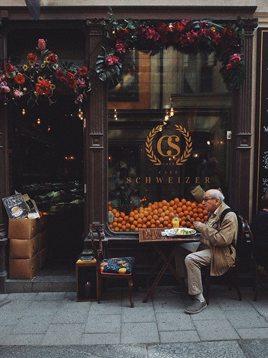 Photo of an elderly man having breakfast at a small café