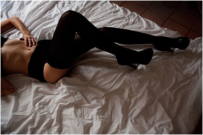 Boudoir photo of a woman in black stockings photographed from above