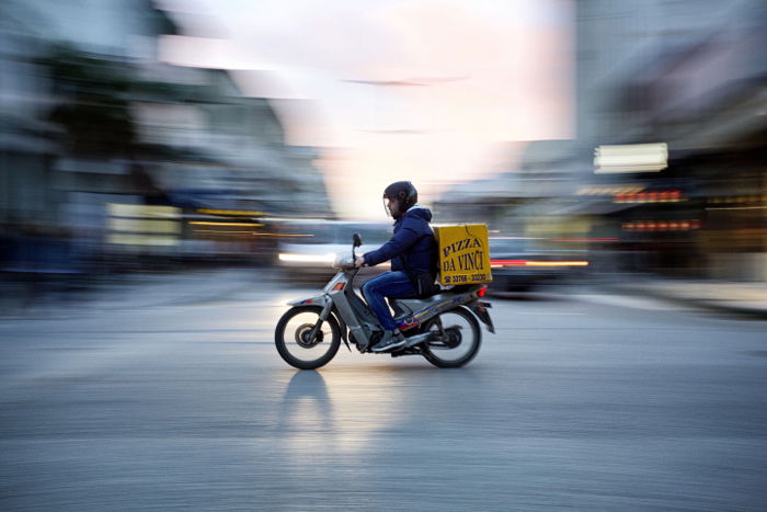 Photo of a man riding a motorcycle with panning photography effects