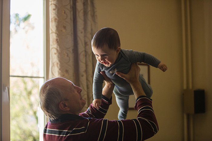 cute family portrait of a granddad playing with grandson