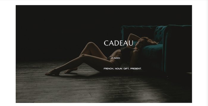 Boudoir photo of a model in front of a green sofa by Cadeau