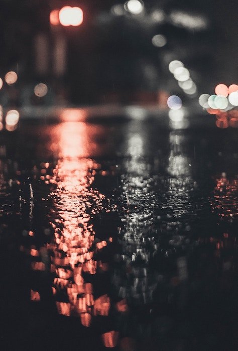 Photo of reflecting light on wet pavement