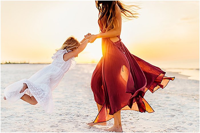 Photo of a woman playing with a little girl on the beach