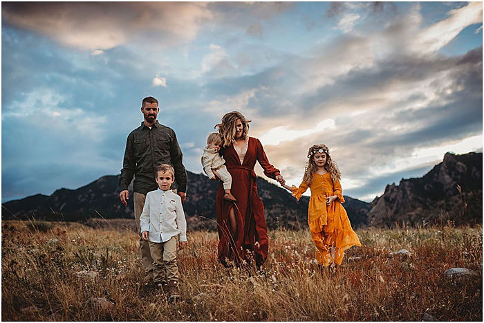 Photo of a family walking on a field with mountains in the background