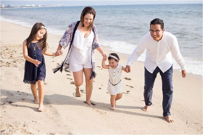 sweet family portrait of parents holding a little girls hand outdoors