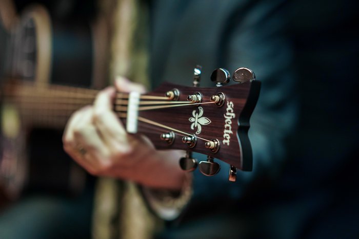 Close-up photo of the hands of a man holding a guitar