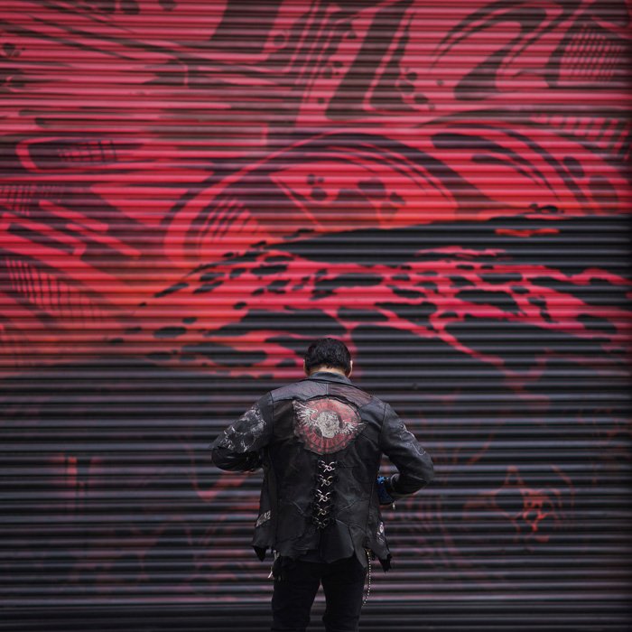 Photo of a man in a leather jacket in front of an abstract background