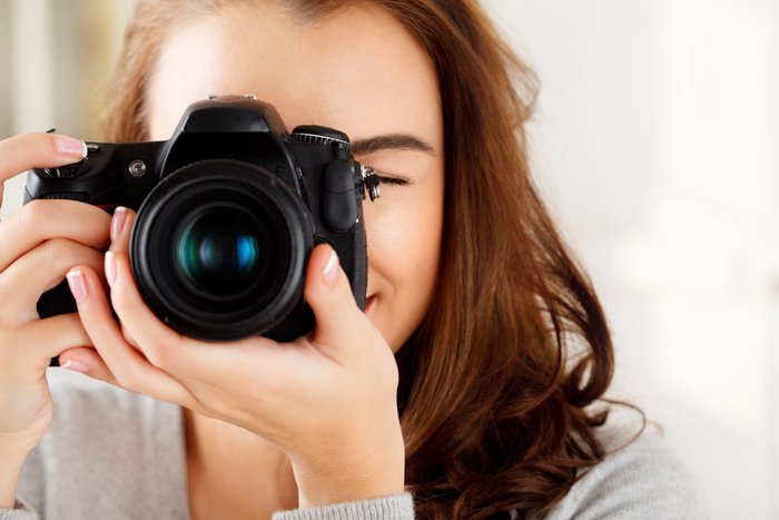 Close-up photo of a woman taking a photo with a dslr camera