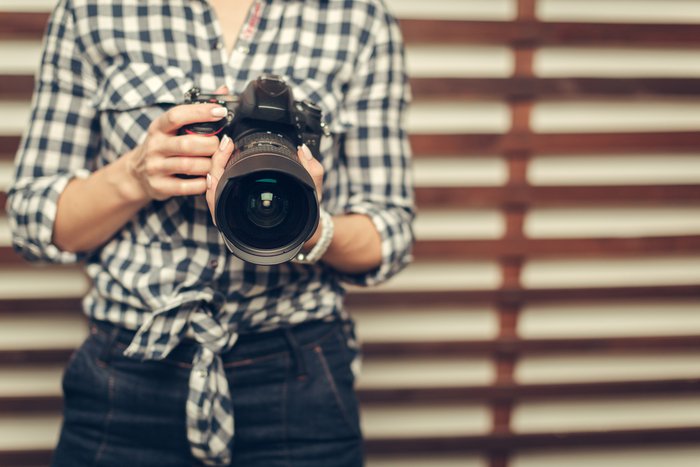 Photo of a woman holding a dslr camera in her hand