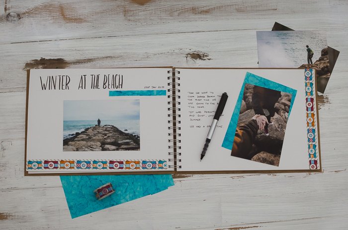overhead view of a notebook, photos and stationary for making a photo journal