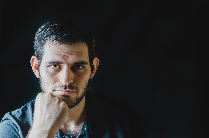 Studio portrait photo of a man using split lighting