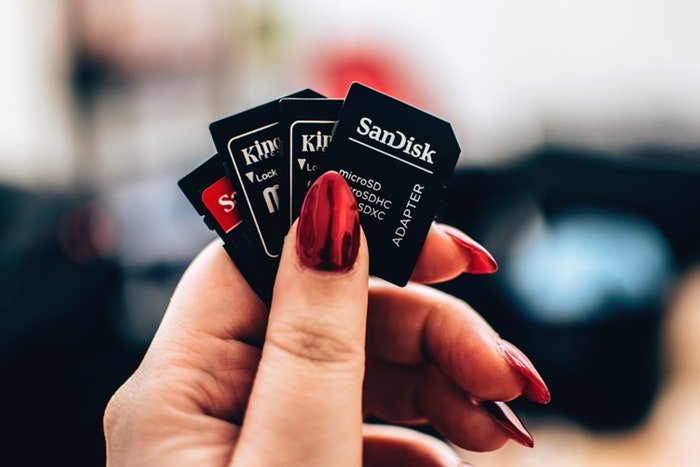 Photo of a hand holding four different memory cards