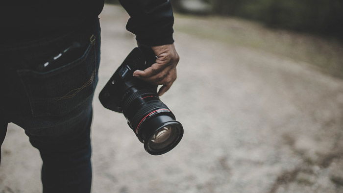 photographer holding the cheapest full frame dslr by his side