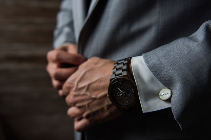 a close up of a man buttoning a suit jacket