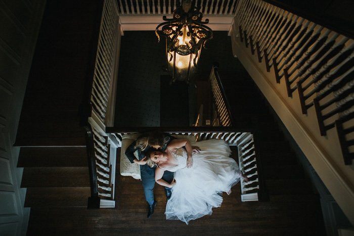 an overhead portrait of a newlywed couple posing on a staircase 