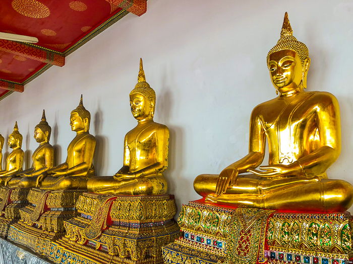 a row of ornate golden buddhas