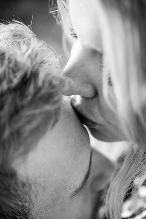 A black and white shot of a couple kissing