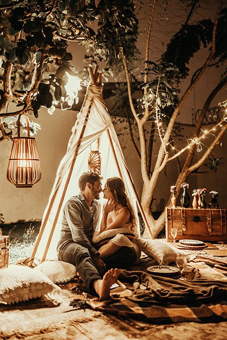 A couple sitting in an indoor teepee