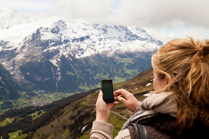 a girl shooting a landscape image on a smartphone