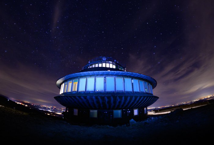 A circular building shot at night with a fish-eye lens