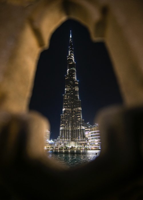 Vertical photography trend: Photo of a skyscraper at night shot through a hole