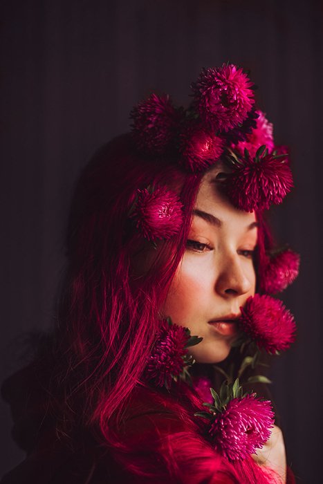Portrait photo of a woman with pink flowrs in her hair