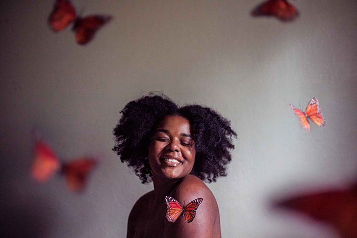 Portrait photo of a woman with butterflies around her