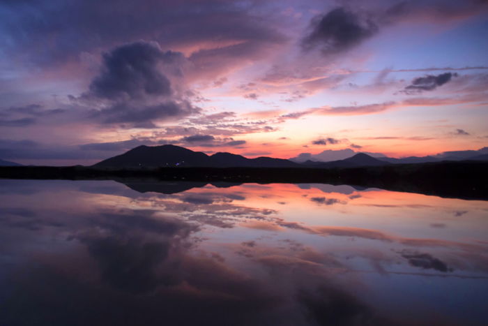 Photo of a lake and mountains at sunset