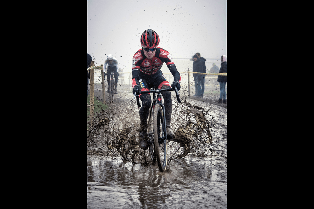 A bike racer riding through mud as an example of cycling photography