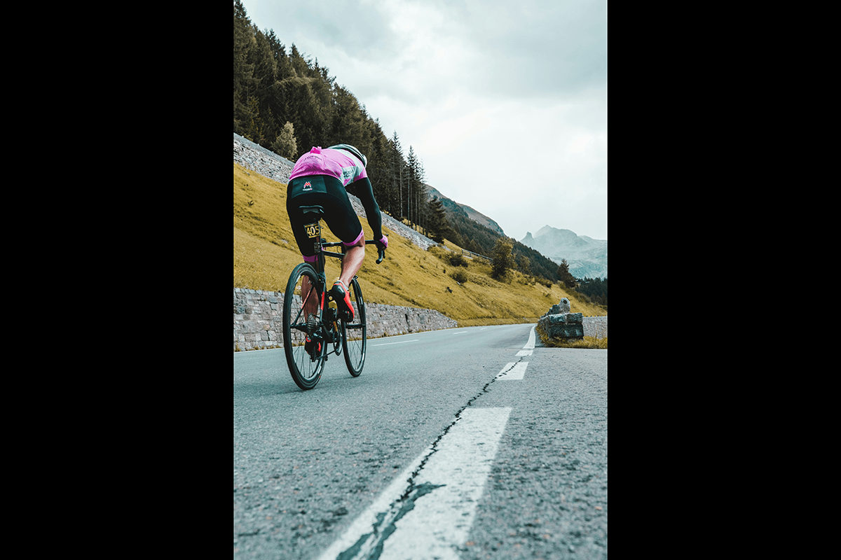 A long-angle shot of a road cyclist on a mountain road