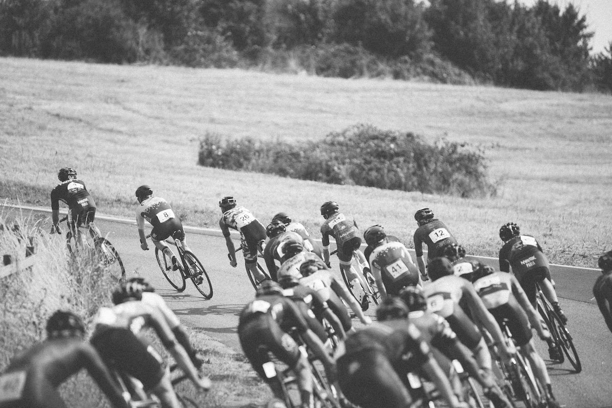 A group of cyclists turning a corner taken in black and white as an example of cyclist photography