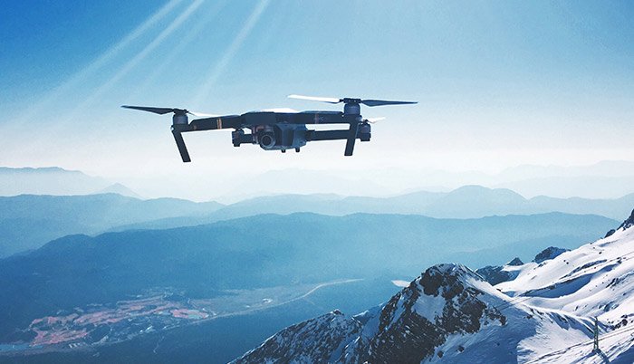 A drone flying above snowy mountains 