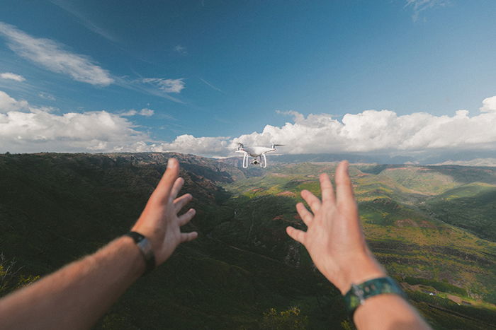 et foto af hænder give slip på en flyvende drone 